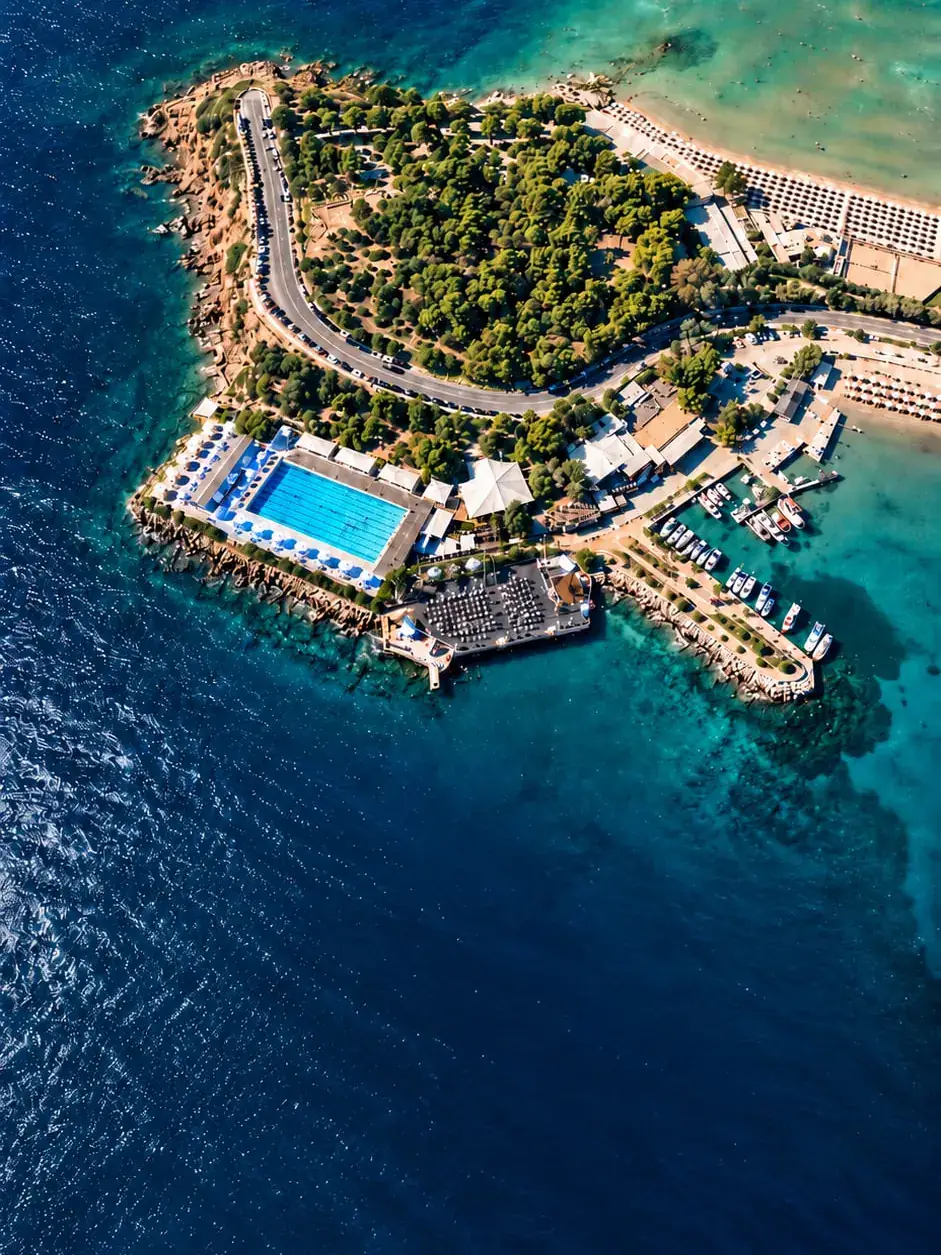 Aerial view of the Nautical Club of Vouliagmeni headland, pool and marina